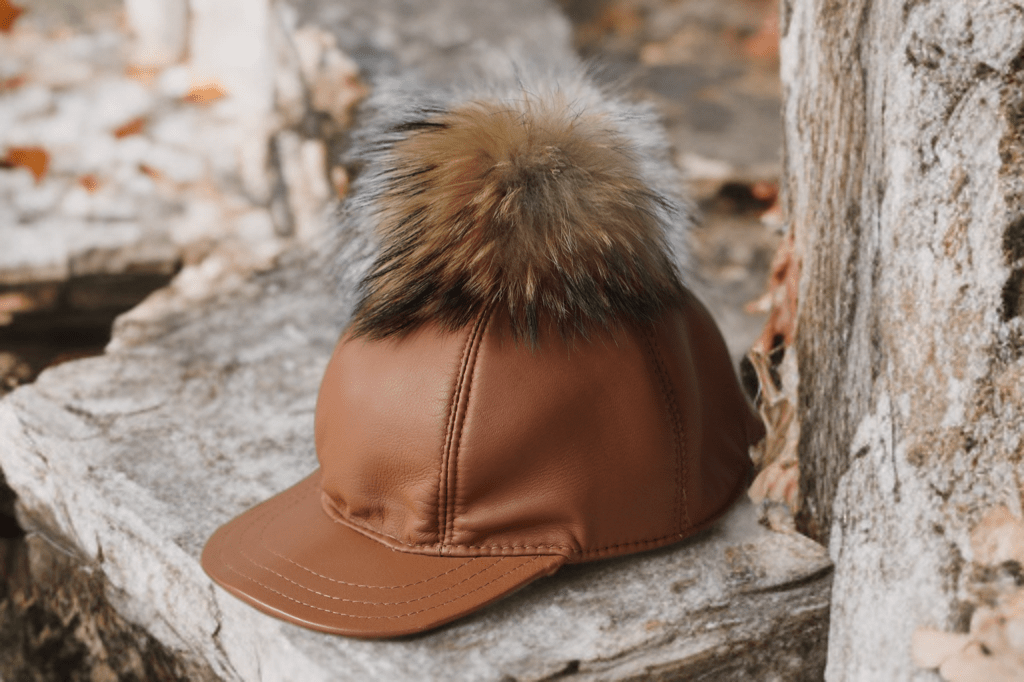 Czapka skórzana z daszkiem damska karmel SKÓRA-1-LEU. Czapka ze skóry naturalnej z pomponem futra naturalnego jenota.
