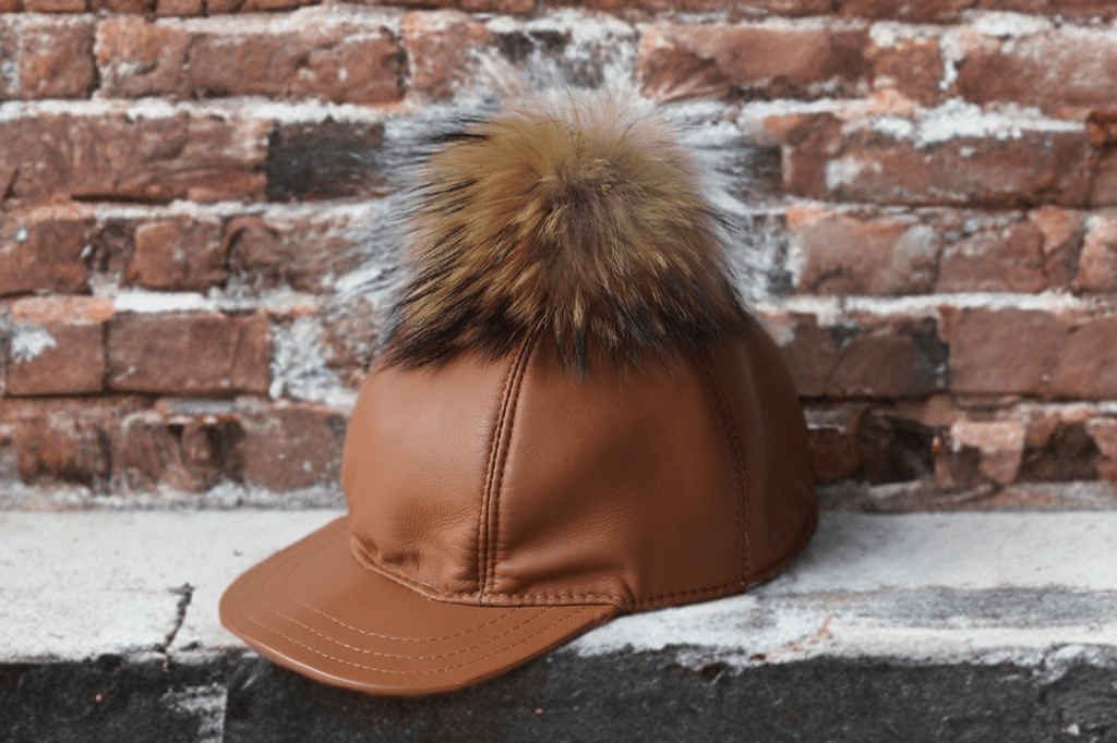 Czapka skórzana z daszkiem damska karmel SKÓRA-1-LEU. Czapka ze skóry naturalnej z pomponem futra naturalnego jenota.